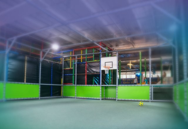 Indoor-Fußballfeld mit Flutlicht und Basketballkorb für sportliche Aktivitäten