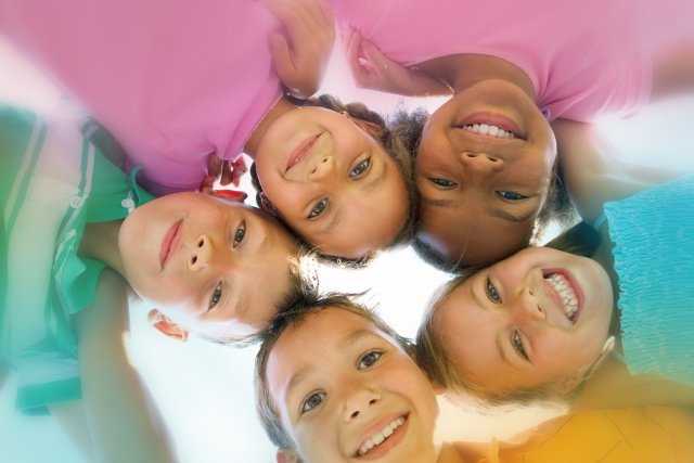 Fröhliche Schulkinder in bunten T-Shirts bei einem Gruppenausflug